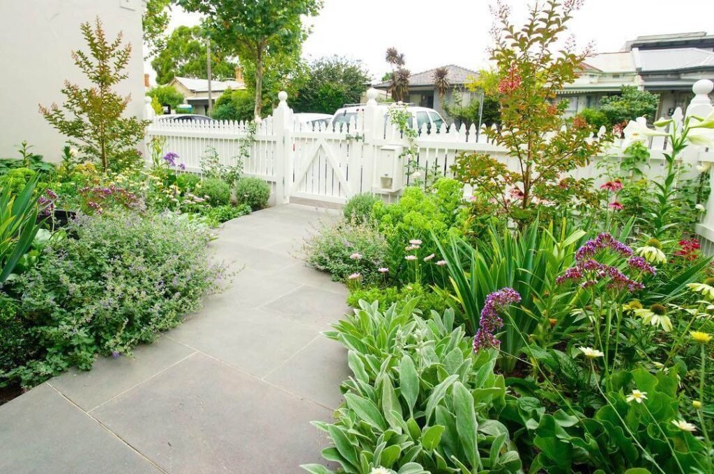 19. Cottage-Inspired Garden Path with a White Picket Gate