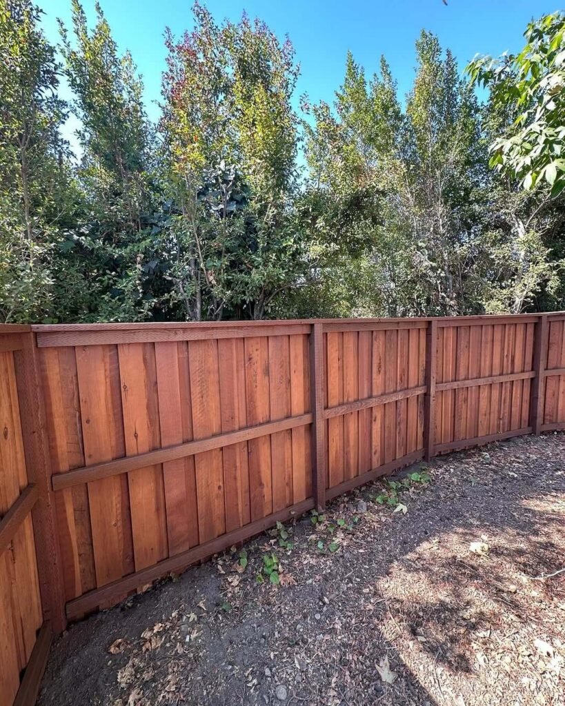 5. Dark-Stained Redwood Fence for Natural Contrast