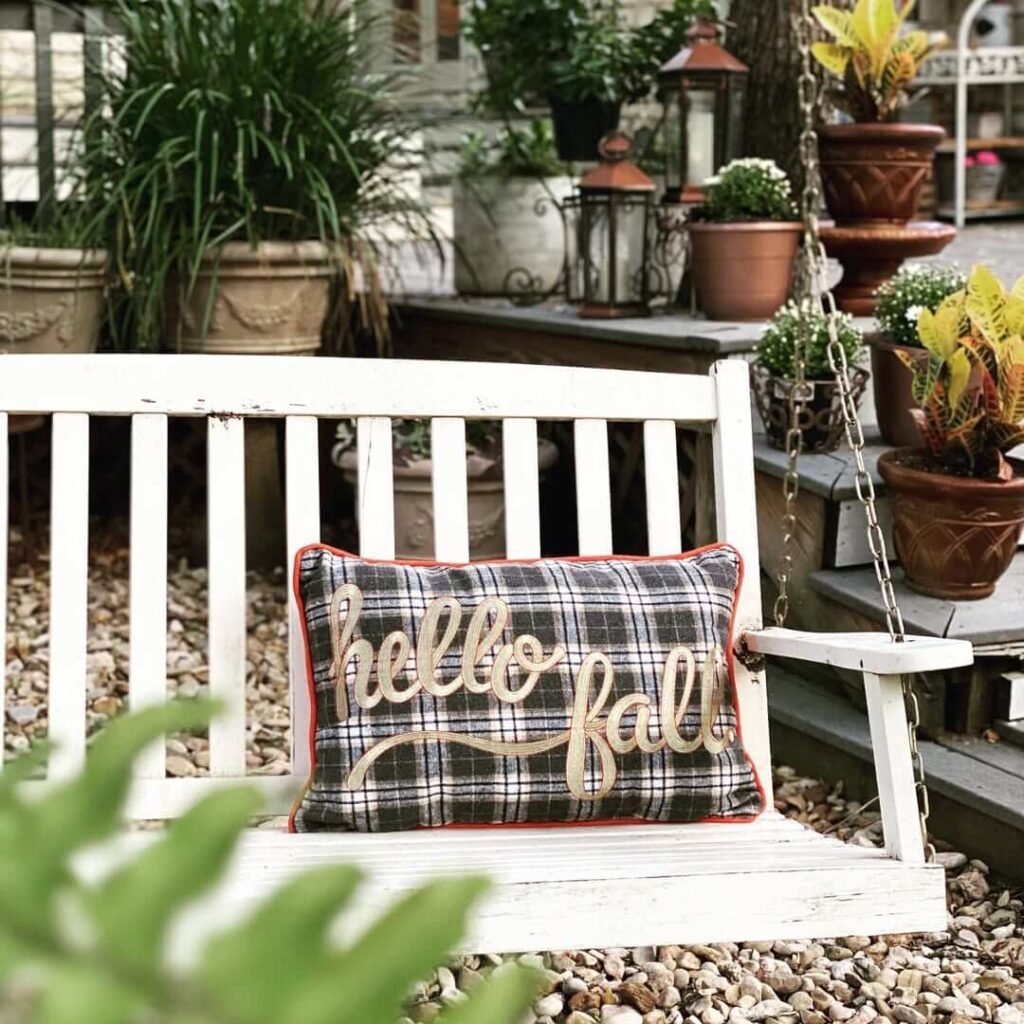 10. Welcoming Fall Porch Swing with Plaid Pumpkins