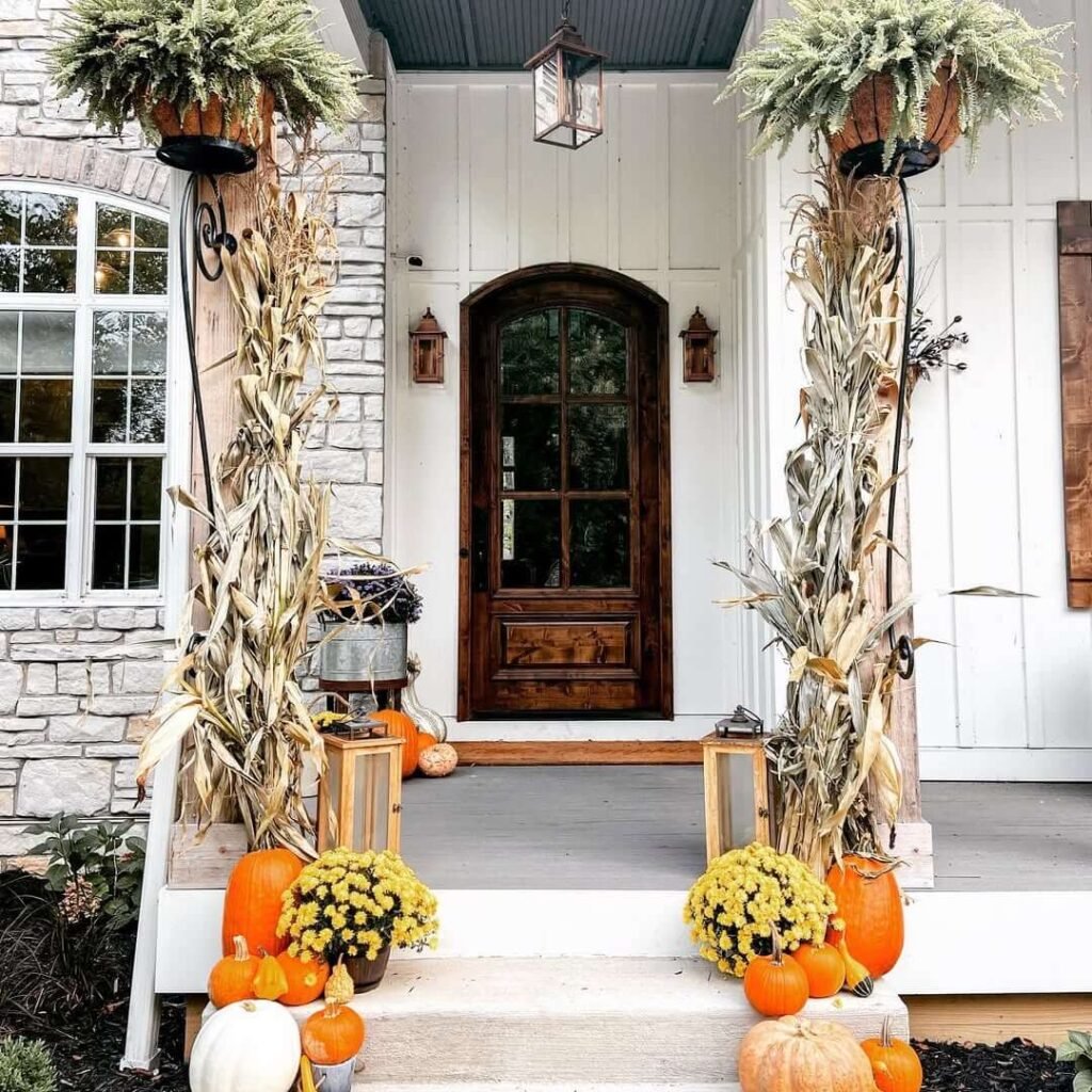 15. Elegant Farmhouse Porch with Cornstalk Columns and Golden Mums